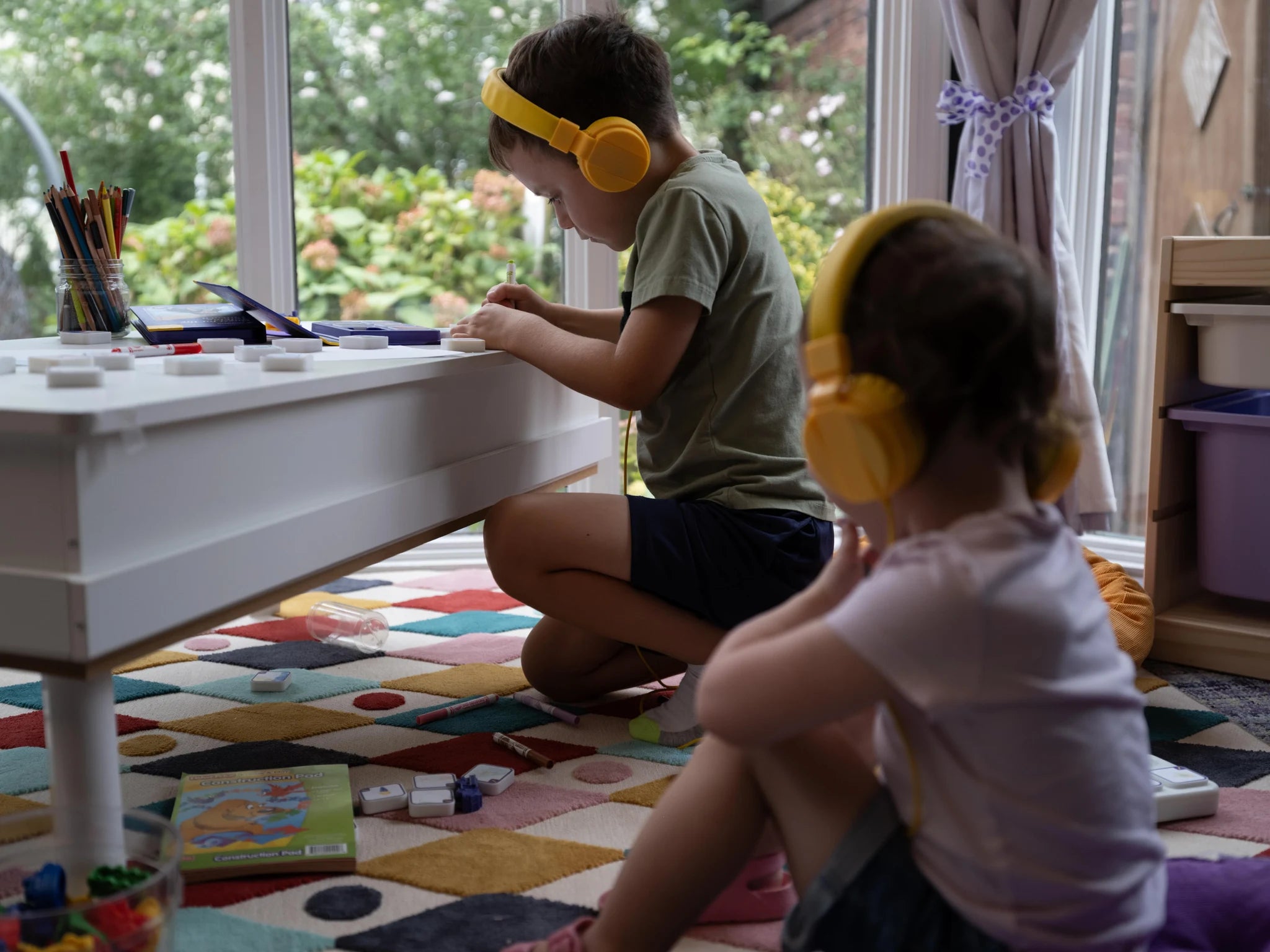 Children listening to stories with yellow headphones.